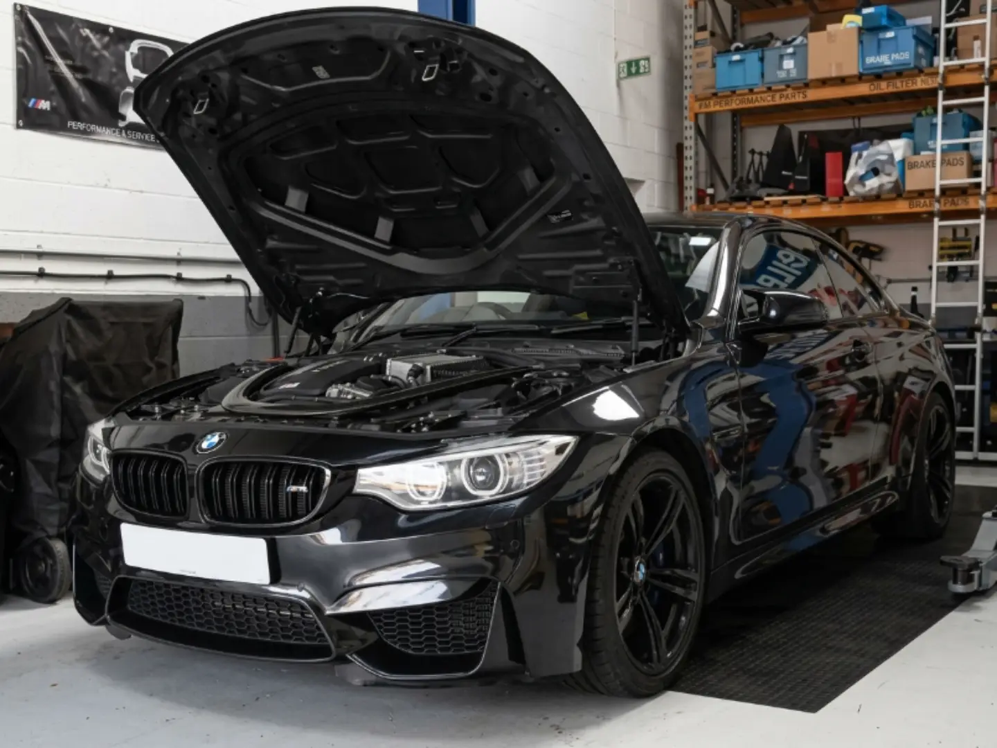 BMW technician completing a repair at the Exotic Auto Services workshop in Musaffah
